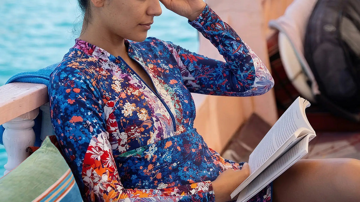woman reading while on holidays and wearing UPF50+ sun protective clothing