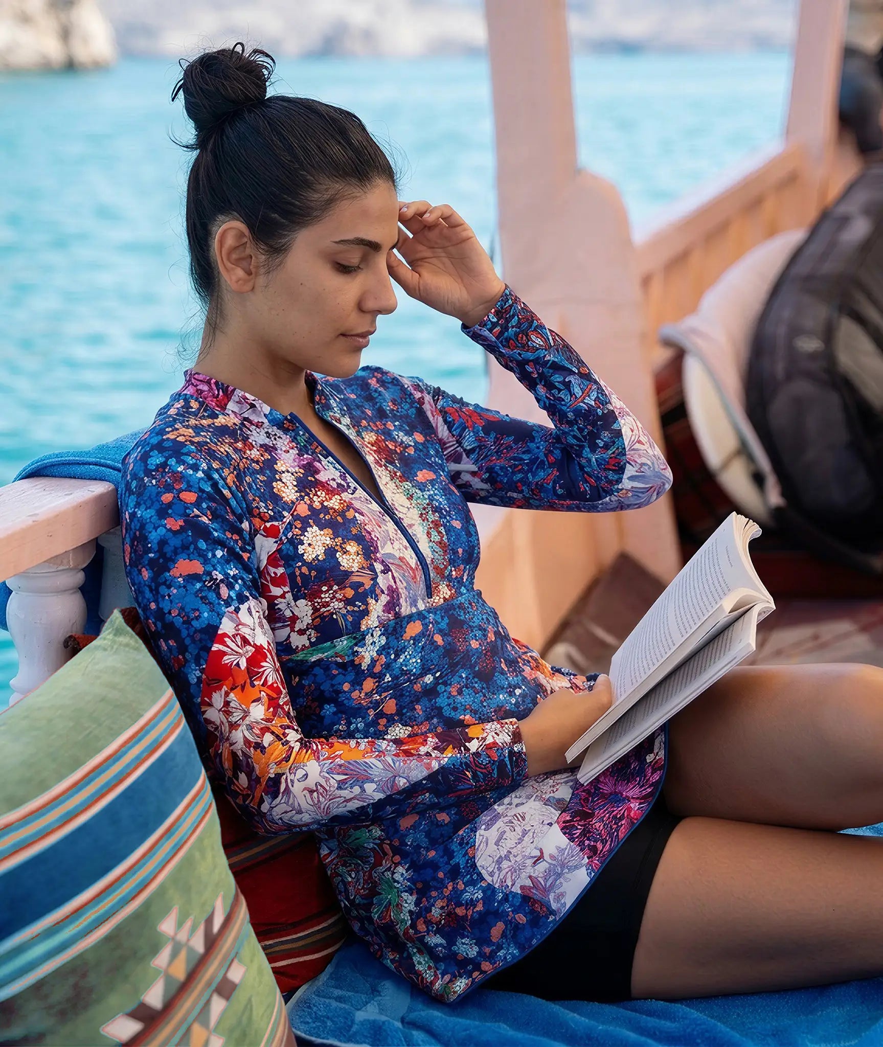 woman reading while on holidays and wearing UPF50+ sun protective clothing